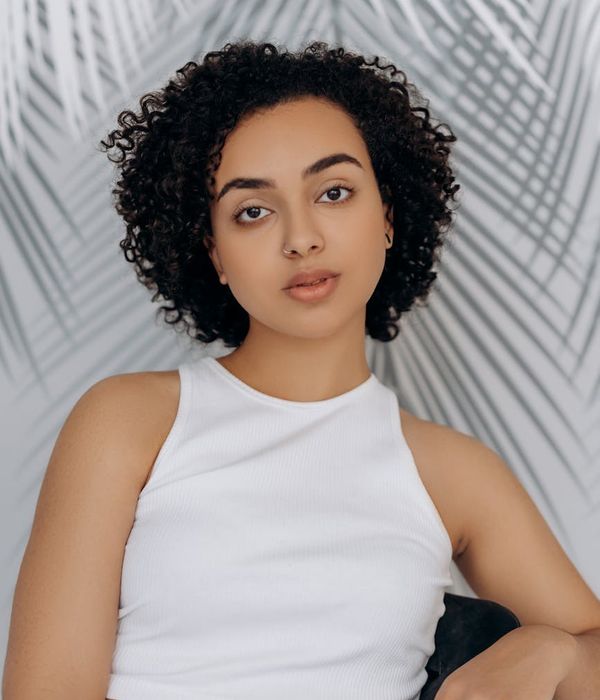 Woman calmly looking at a distant object with a serene background.